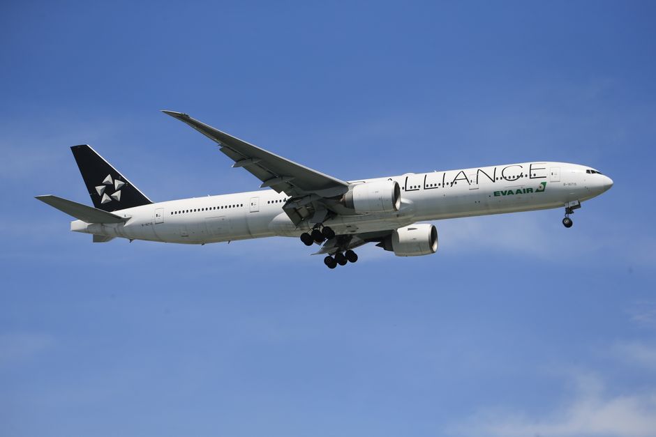 Wide-body airliner in flight captured against a clear blue sky, showcasing aviation dynamics.