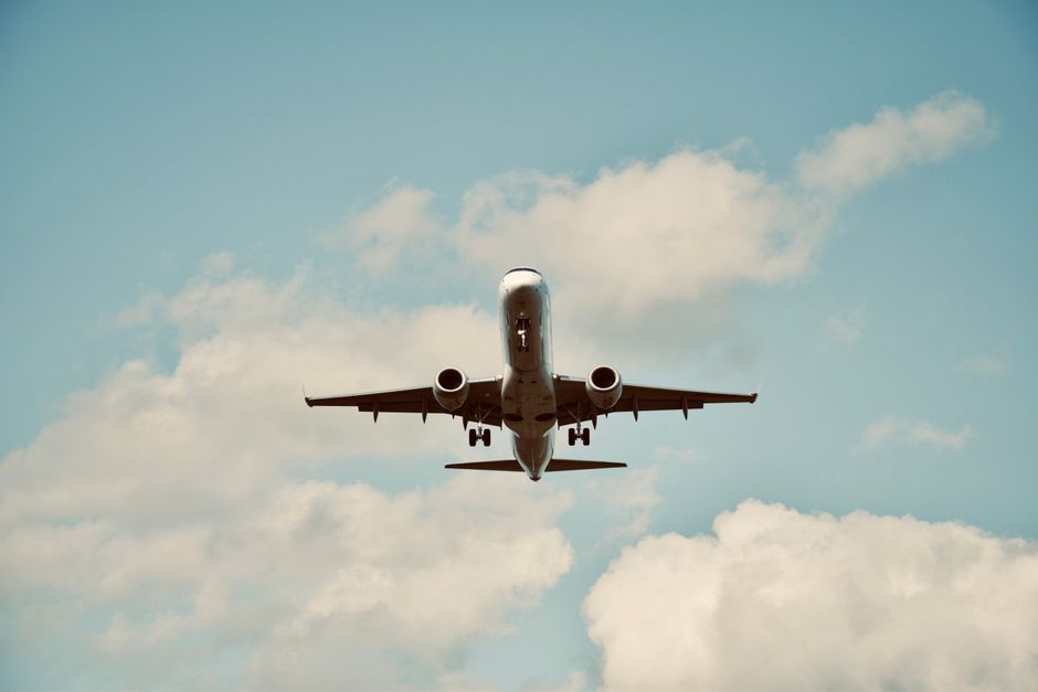 Passenger airplane flying against a blue sky with clouds, captured in Kraków, Poland.