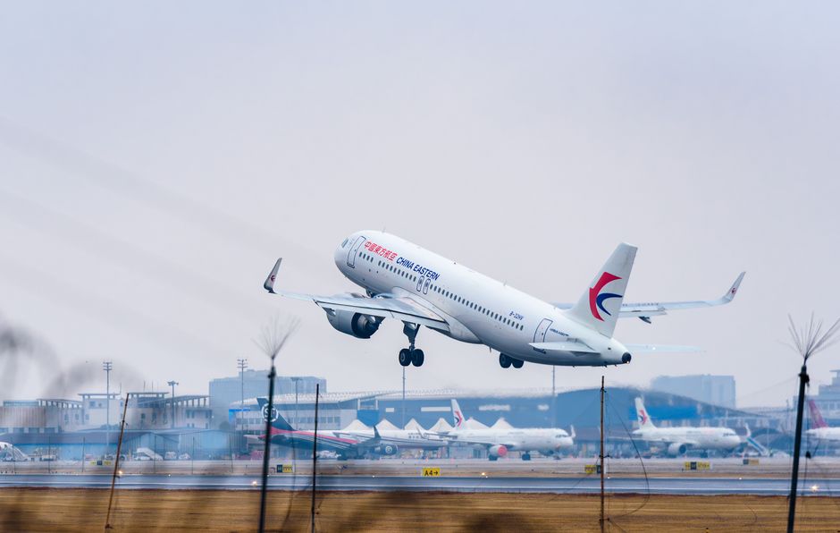 A China Eastern airplane taking off on a cloudy day at an airport.